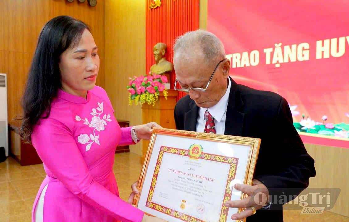 Đồng chí Phó Bí thư Đảng ủy phường Đồng Hới Nguyễn Thị Nguyên trao tặng Huy hiệu Đảng cho đảng viên lão thành - Ảnh: P.V