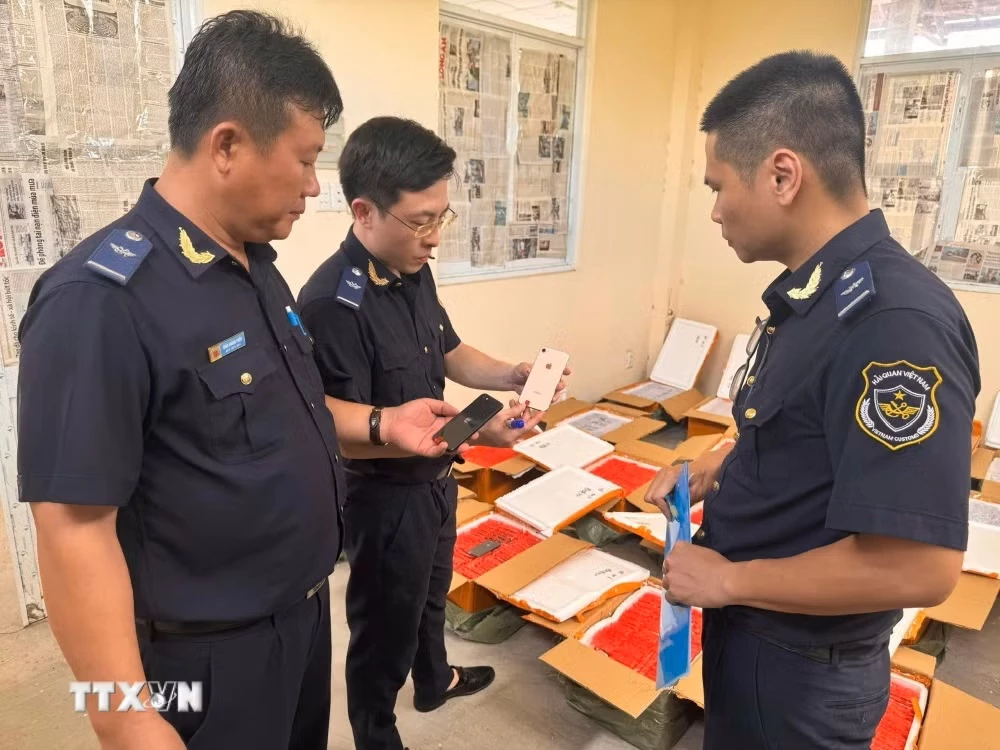 Lực lượng Hải quan tiến hành kiểm tra đối với lô hàng điện thoại di động quá cảnh nghi vấn đã qua sử dụng không thể hiện xuất xứ. (Ảnh: TTXVN phát)