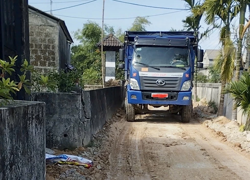 Xe chở đất, vật liệu phục vụ thi công khu tái định cư xã Triệu Độ khiến đường bê tông ở kiệt số 5, thôn An Lợi sụt lún -Ảnh: N.B