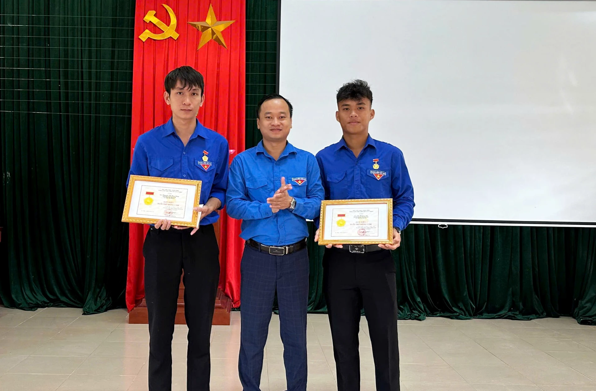 Hai đoàn viên Võ Hoàng Vũ và Nguyễn Võ Huy Công vinh dự nhận Huy hiệu “Tuổi trẻ dũng cảm” của Ban Bí thư Trung ương Đoàn - Ảnh: T.L