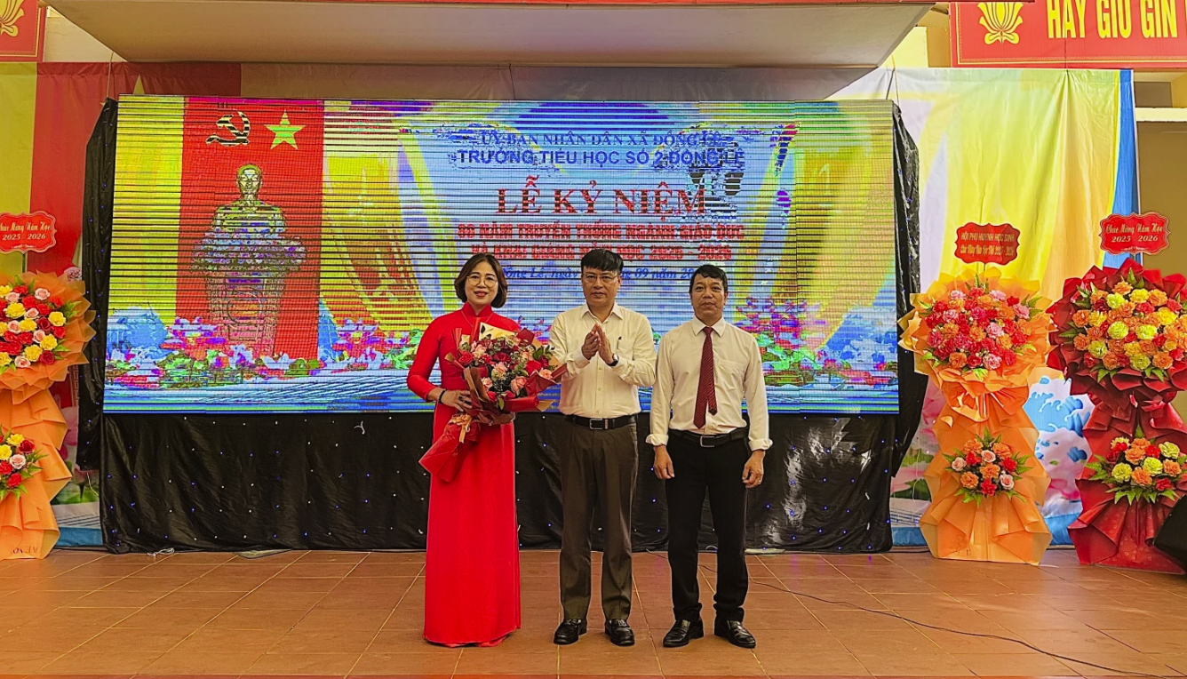 Giám đốc Công an tỉnh, Thiếu tướng Nguyễn Thanh Liêm tặng hoa chúc mừng tập thể Trường Tiểu học số 2 Đồng Lê - Ảnh: B.N