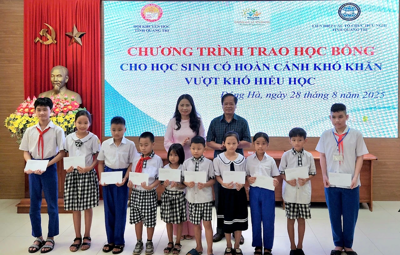 Phó Chủ tịch Hội Khuyến học tỉnh Dương Thị Hải Yến cùng nhà tài trợ trao học bổng cho học sinh có hoàn cảnh khó khăn - Ảnh: N.B