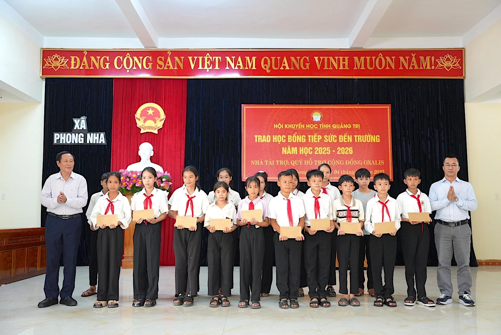 Hội Khuyến học tỉnh Quảng Trị và đại diện Quỹ hỗ trợ cộng đồng Oxalis trao học bổng cho các em học sinh tại xã Phong Nha.