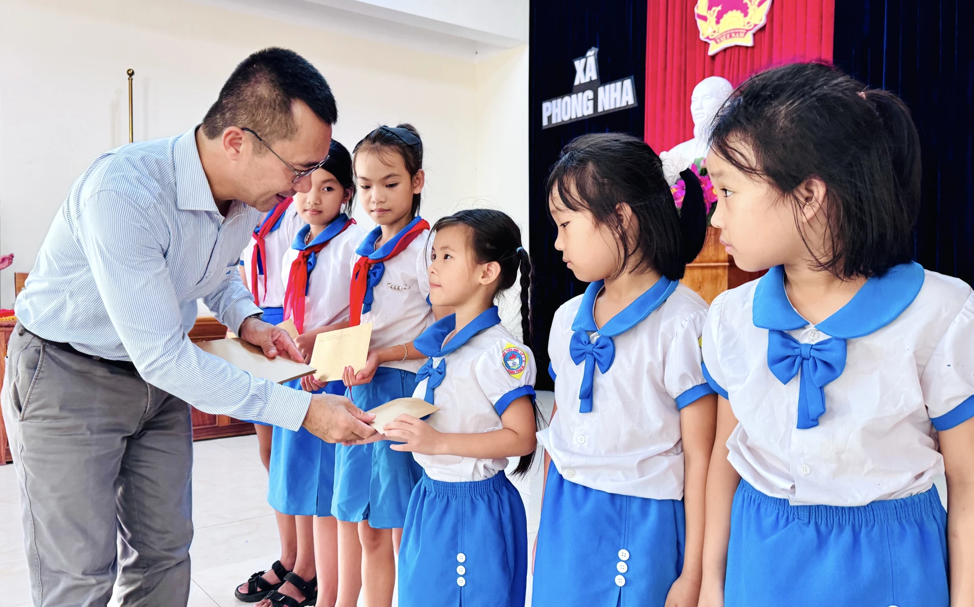 Đại diện Quỹ hỗ trợ cộng đồng Oxalis trao học bổng cho các em học sinh tại xã Phong Nha.