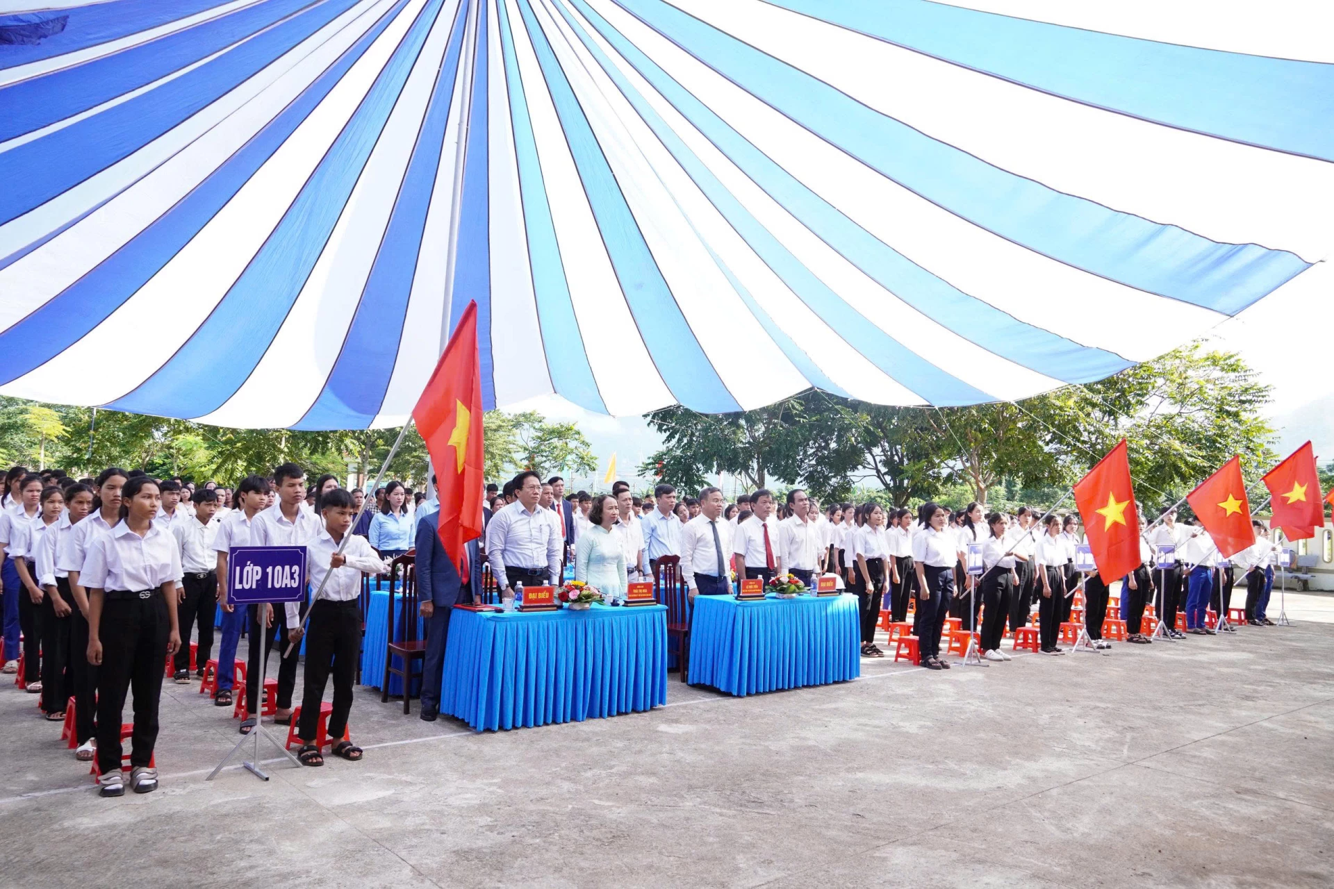 Phó Chủ tịch UBND tỉnh Lê Đức Tiến cùng tập thể ban giám hiệu, giáo viên và học viên Trung tâm Giáo dục Nghề nghiệp - Giáo dục thường xuyên khu vực Hướng Hoá thực hiện nghi thức chào cờ 