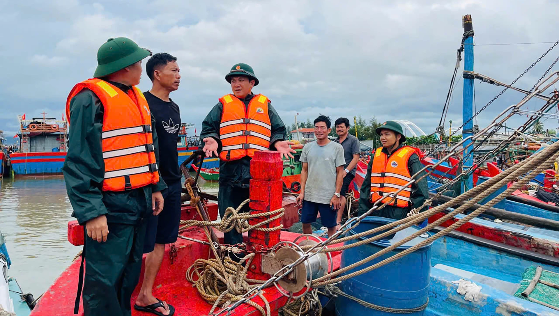 Cán bộ, chiến sĩ Đồn Biên phòng Nhật Lệ tuyên truyền, hướng dẫn bà con neo đậu, bảo vệ an toàn tài sản - Ảnh: N.M