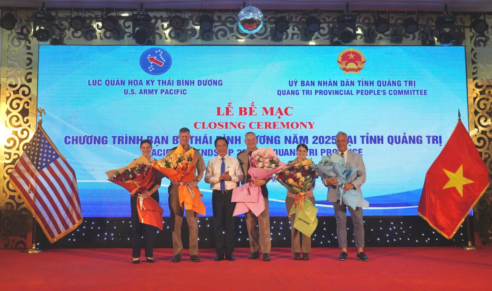 Phó Chủ tịch Thường trực UBND tỉnh Hoàng Nam tặng hoa chúc mừng các đối tác Hoa Kỳ - Ảnh: QN
