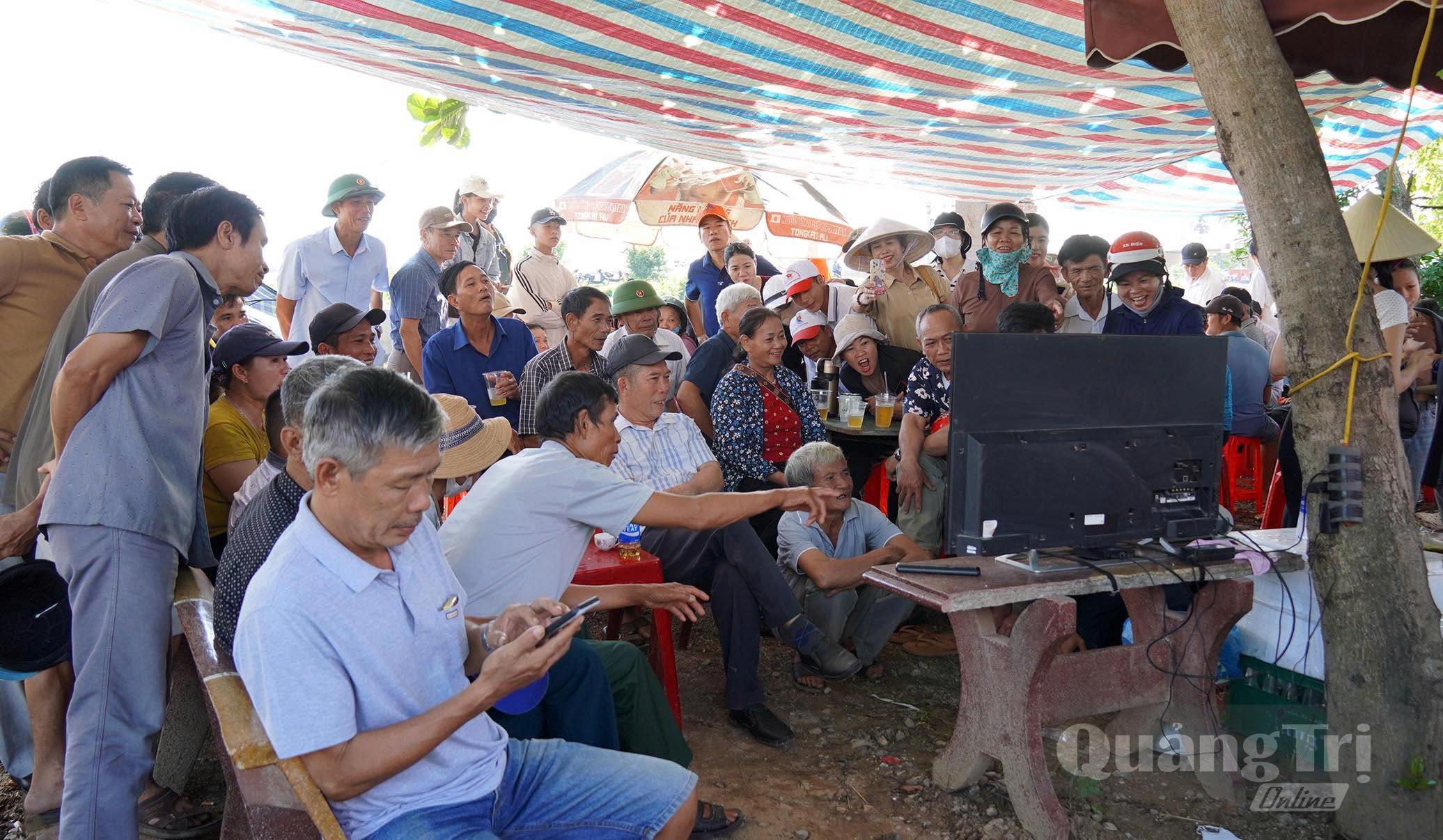 Vừa xem đua, bơi trên sông, vừa cập nhật tình hình qua truyền hình trực tiếp.