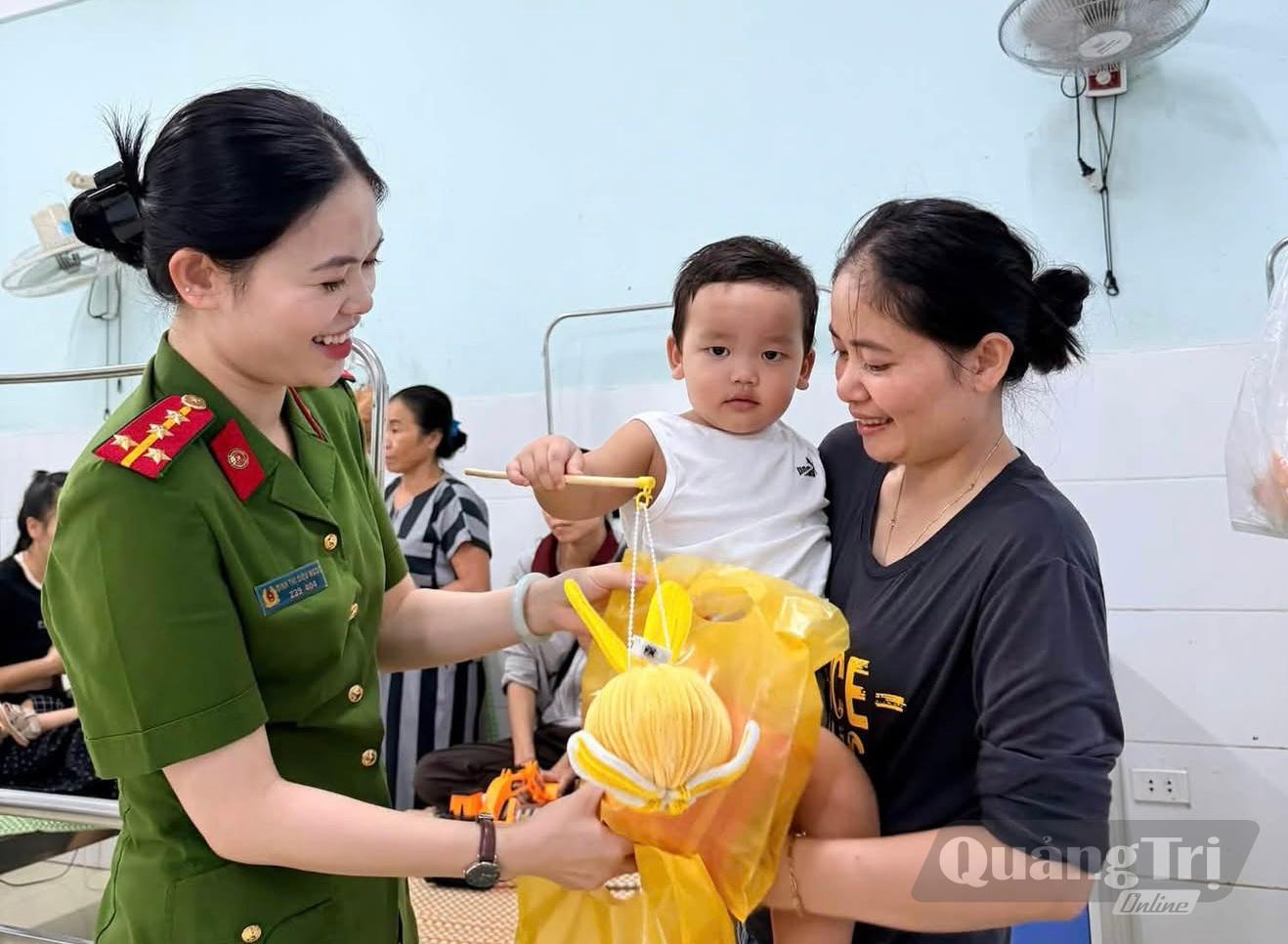 Cán bộ Công an xã Minh Hóa trao quà Trung thu, động viên bệnh nhi đang điều trị tại Bệnh viện đa khoa Minh Hóa - Ảnh: M.H