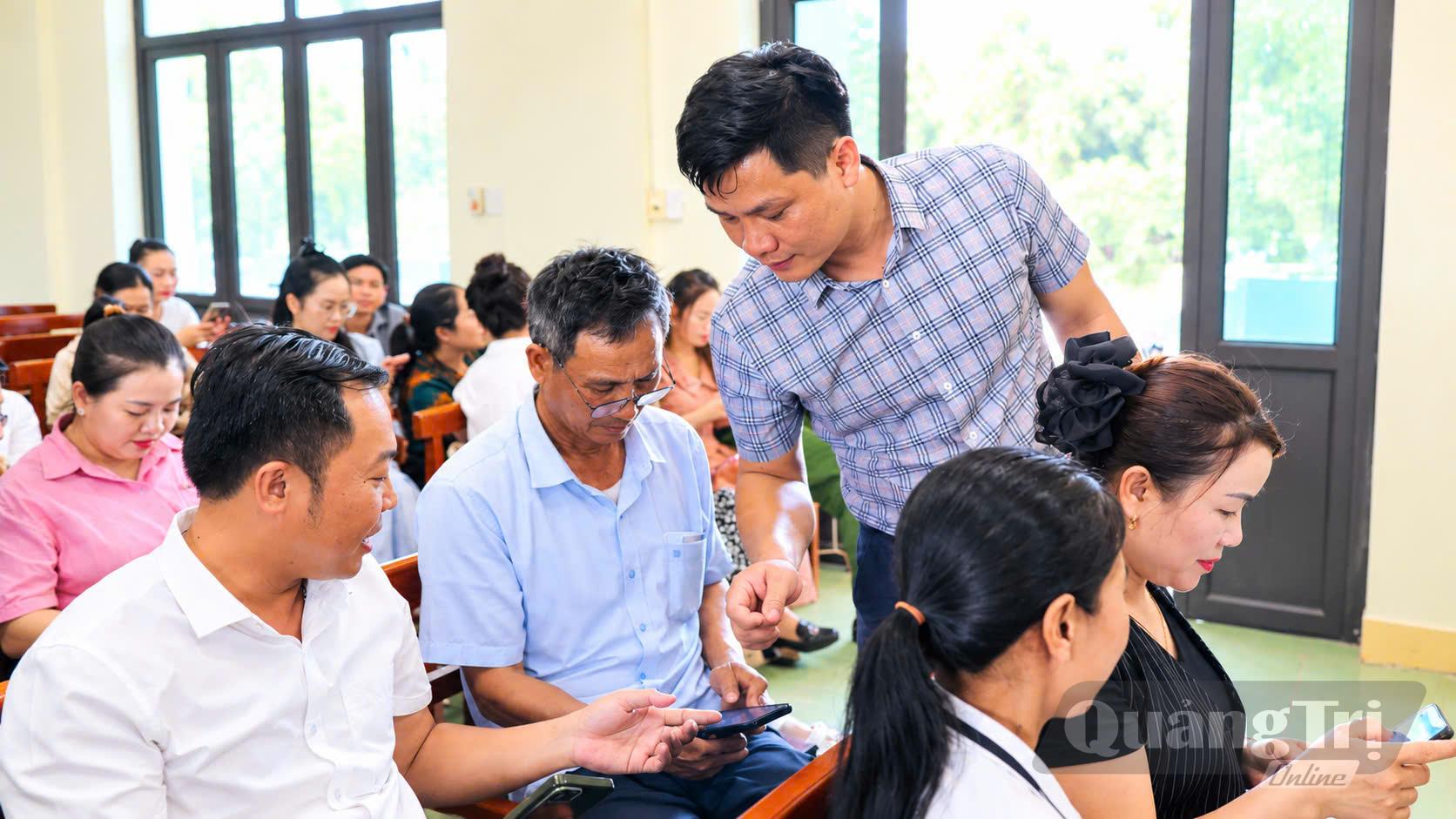 Cán bộ xã hướng dẫn người dân cài đặt, sử dụng công nghệ số - Ảnh: P.N