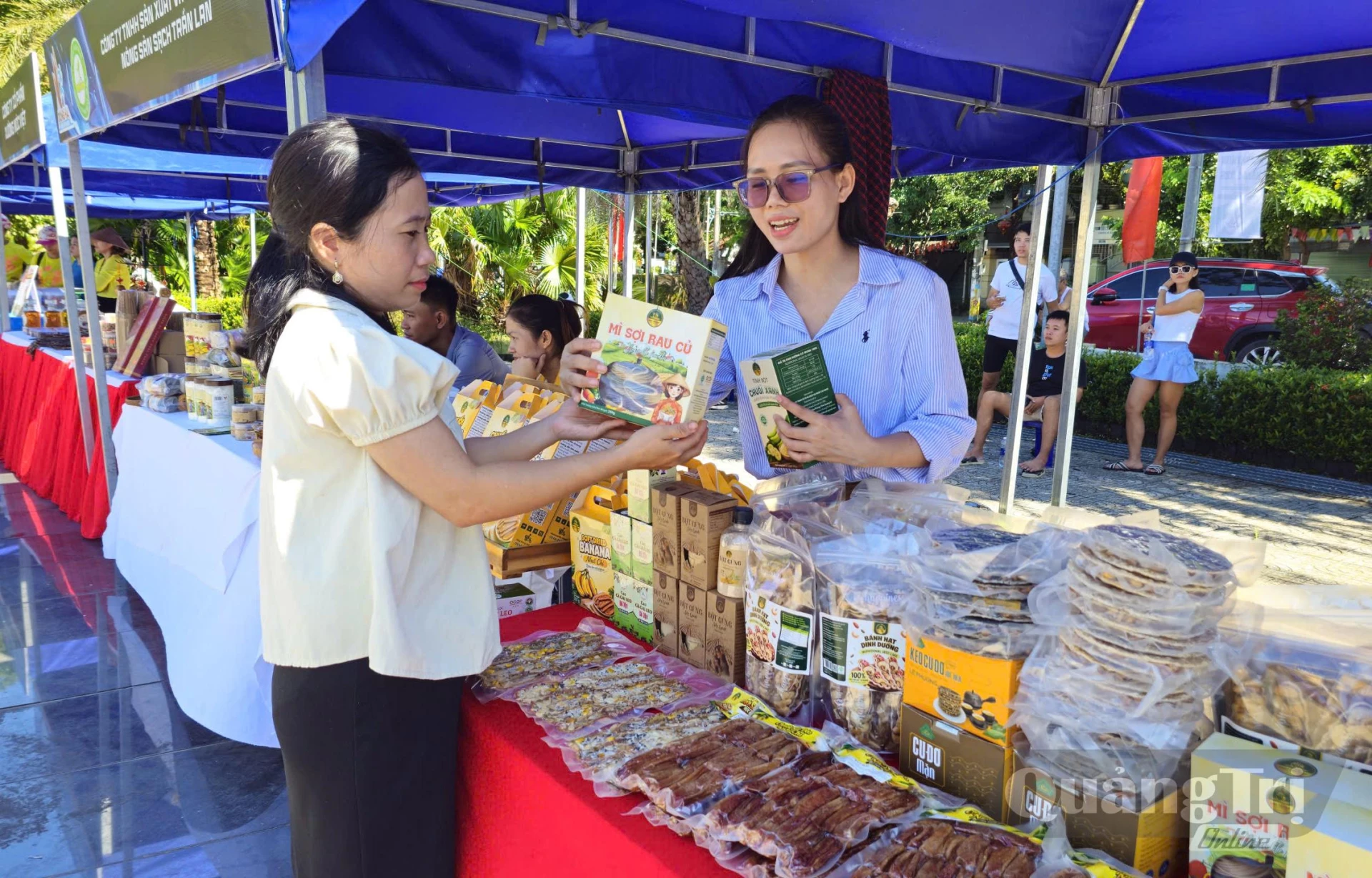 Chị Trần Thị Lan Chi (đeo kính) giới thiệu sản phẩm tại sự kiện giải chạy Đông Hà Marathon 2026 - Ảnh: N.T.H