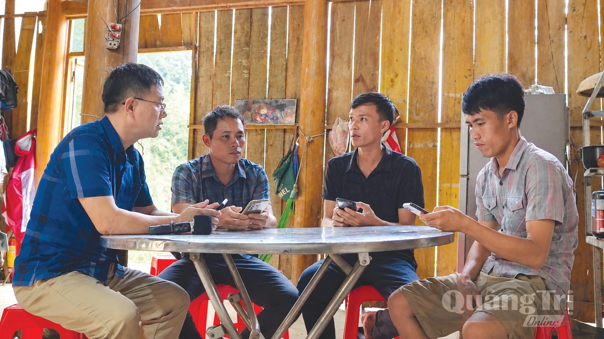 Người dân bản Ka Tang xem thông báo trên nhóm zalo cộng đồng để chủ động ứng phó với mưa lớn do áp thấp nhiệt đới ngày 13/9/2026 - Ảnh: N.M.P