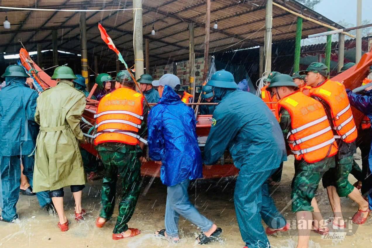 Lực lượng chức năng hỗ trợ người dân di dời tài sản tại xã Mỹ Thủy - Ảnh: Q.V