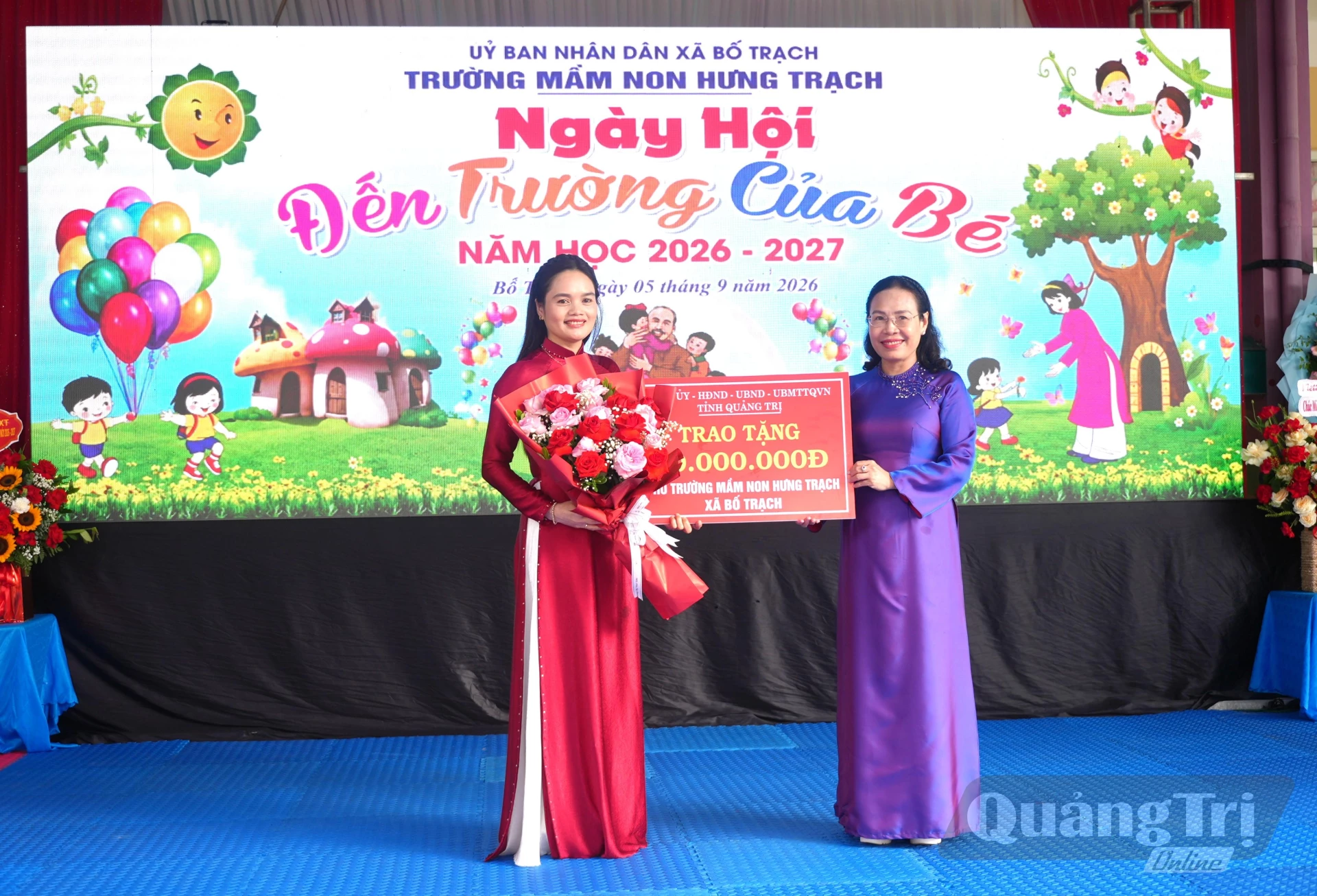 Đồng chí Phạm Thị Hân, Phó Chủ tịch Thường trực HĐND tỉnh tặng hoa và quà cho cô và trò Trường Mầm non Hưng Trạch - Ảnh: T.Đ


