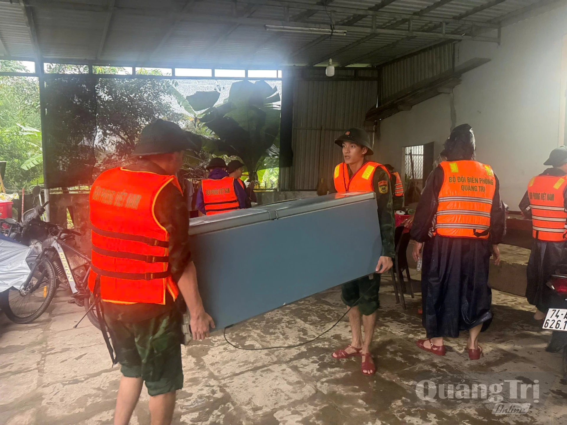 Cán bộ chiến sĩ Đồn Biên phòng Cửa khẩu Lao Bảo giúp dân di dời tài sản đến nơi an toàn. - Ảnh: P.K