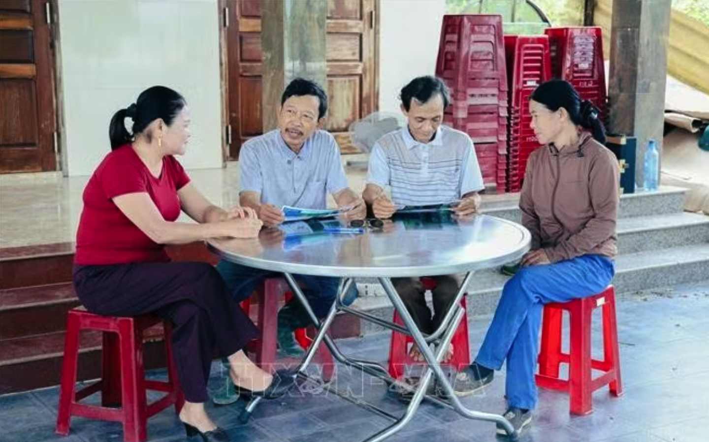 Ông Trần Đình Việt (thứ 2, trái sang) và ông Lê Văn Nam chia sẻ kinh nghiệm về quản lý, chăm sóc và bảo vệ rừng bền vững cho người dân địa phương. Ảnh: TTXVN phát