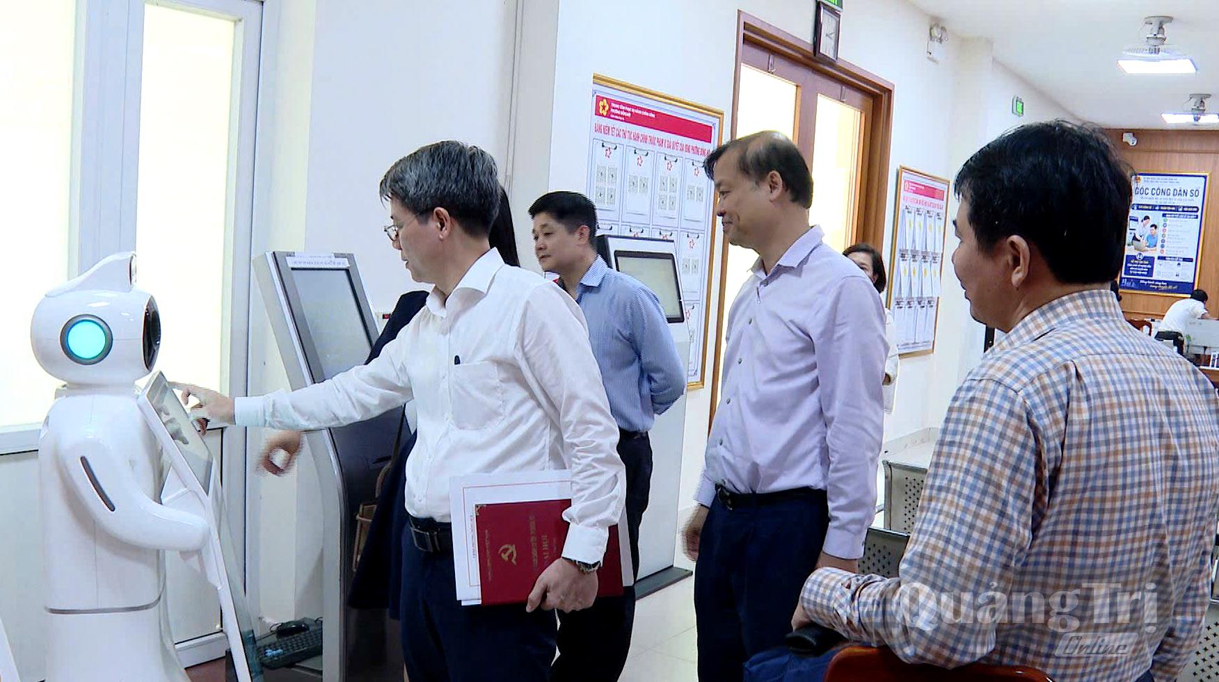 Đồng chí Nguyễn Hoa Cương, Phó Viện trưởng Viện Nghiên cứu chính sách và chiến lược Trung ương và đoàn công tác tìm hiểu việc ứng dụng công nghệ Robot AI tại phường Đồng Hới - Ảnh: H.Tr