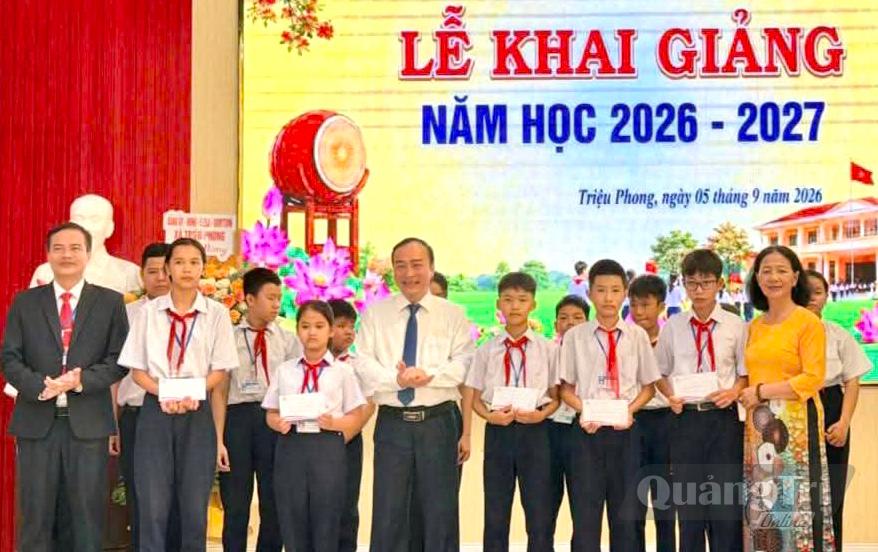 Lãnh đạo xã Triệu Phong cùng đại diện Quỹ học bổng cho con trao học bổng cho học sinh Trường THCS Nguyễn Bỉnh Khiêm nhân dịp khai giảng năm học mới - Ảnh: N.B