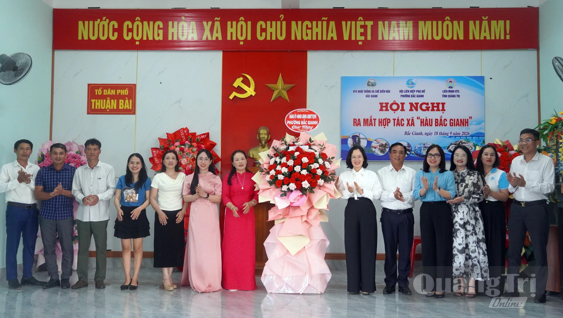 Đại diện lãnh đạo phường Bắc Gianh tặng hoa chúc mừng HTX Nuôi trồng và Chế biến hàu Bắc Gianh - Ảnh: N.M