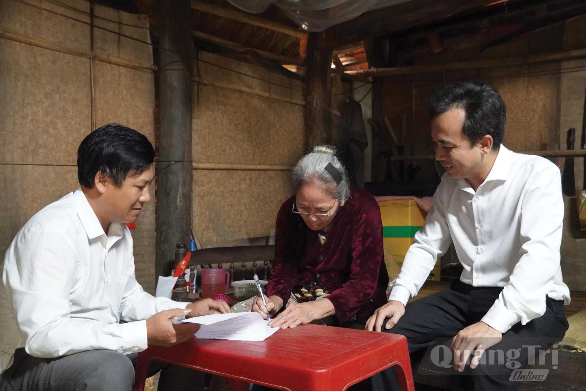 Cán bộ Trung tâm Phục vụ hành chính công xã Tuyên Hóa mang hồ sơ đến tận nhà hỗ trợ bà Phạm Thị Điền, ở thôn Lạc Sơn - Ảnh: H.L