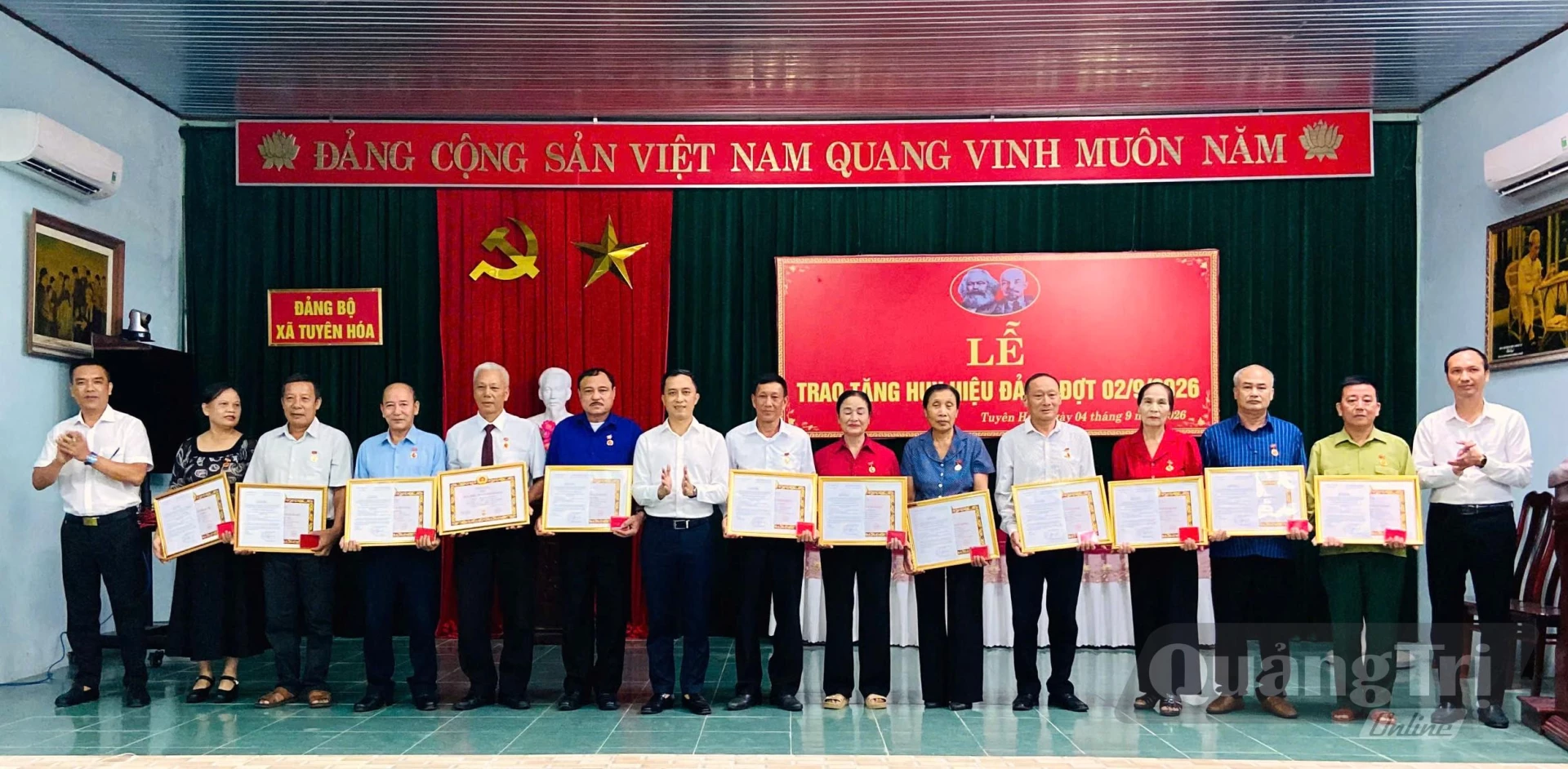 Các đồng chí lãnh đạo xã Tuyên Hóa trao Huy hiệu Đảng và tặng hoa chúc mừng các đảng viên - Ảnh: T.N