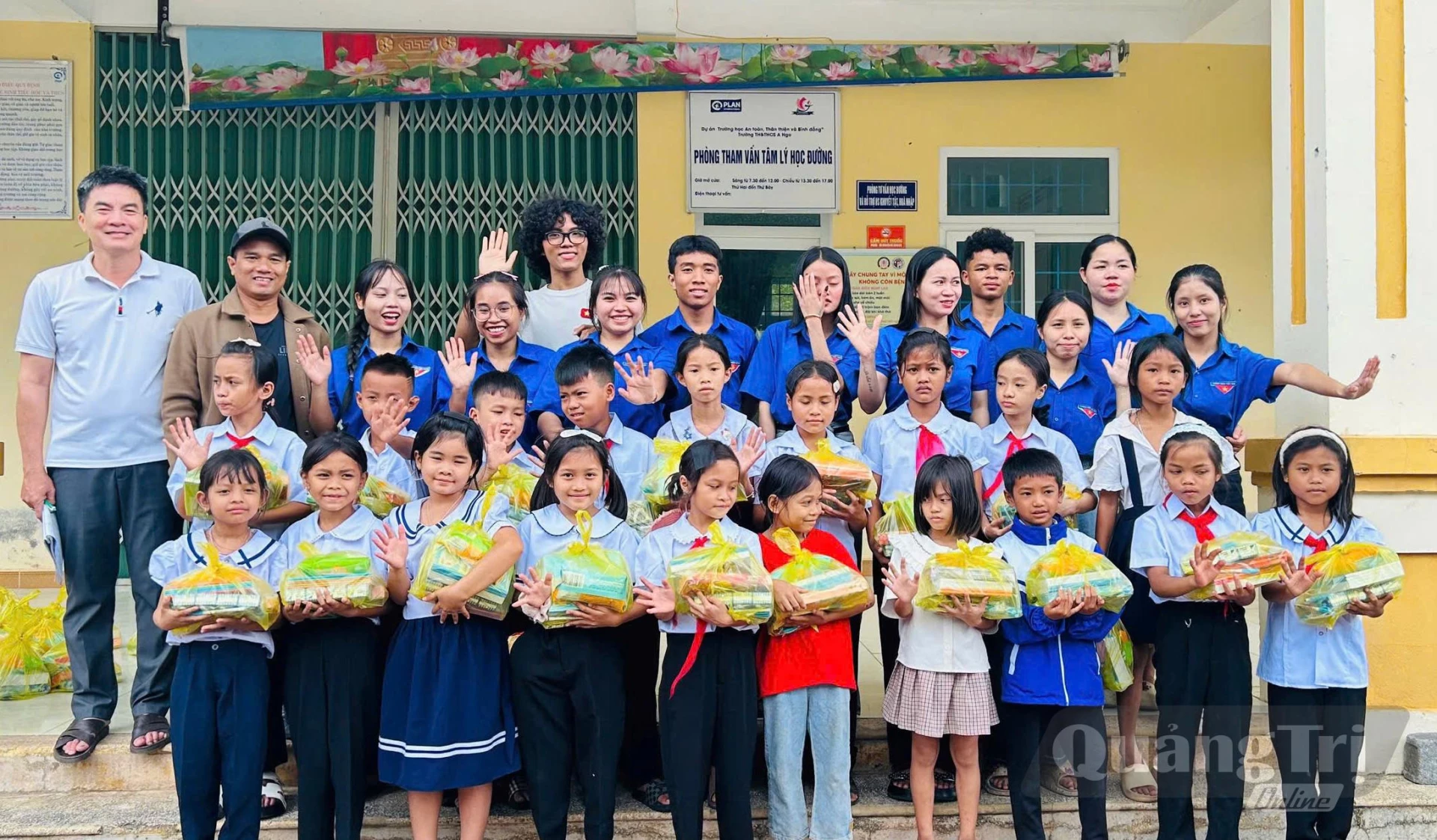 Ka Nụ (áo trắng, đeo kính) trao quà cho các em học sinh Trường tiểu học A Ngo vào đầu tháng 9/2026 - Ảnh: NVCC