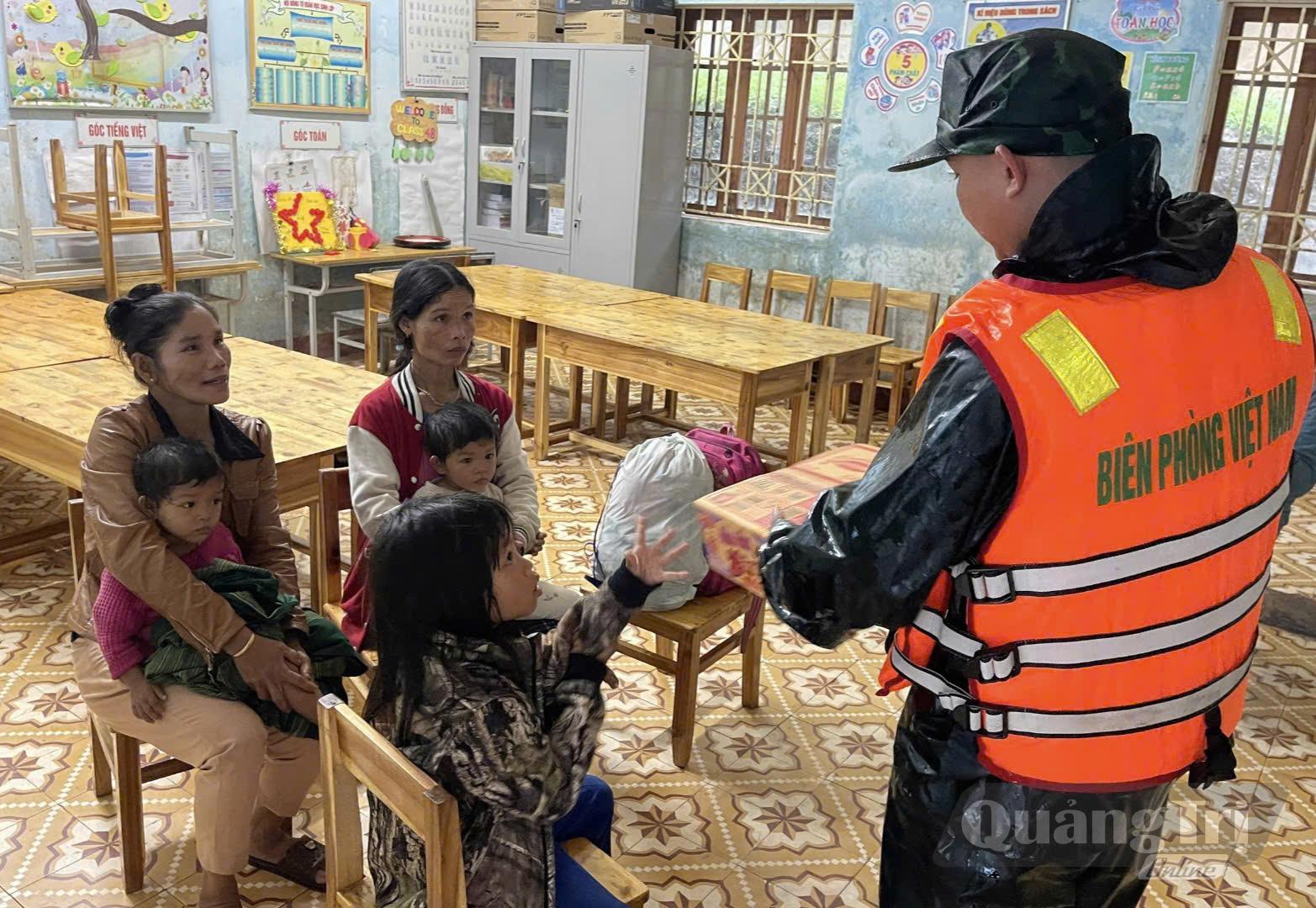 Cán bộ Đồn Biên phòng Ba Nang tổ chức di dời người dân thôn Trại Cá đến nơi an toàn, đồng thời hỗ trợ lương thực, thực phẩm cho các hộ dân - Ảnh: CTV