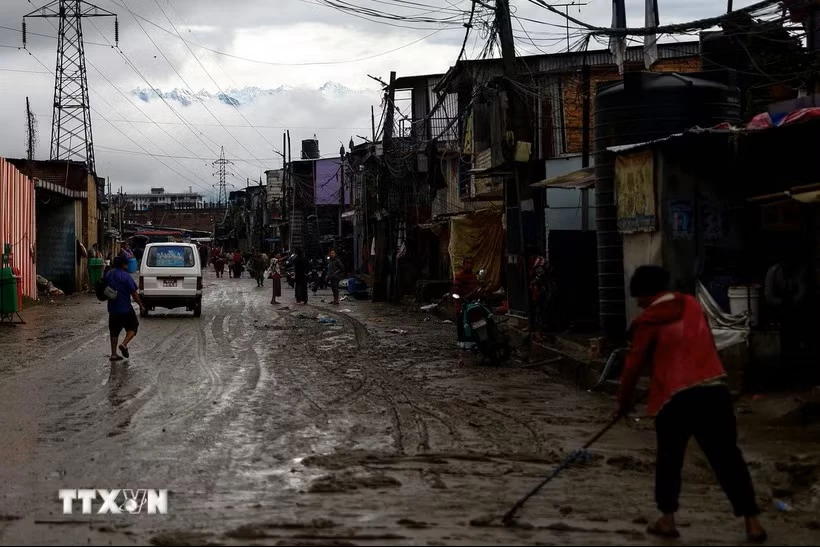 Người dân dọn bùn trên đường phố sau trận lũ quét tại Kathmandu, Nepal, ngày 5/10/2025. (Ảnh: THX/TTXVN)