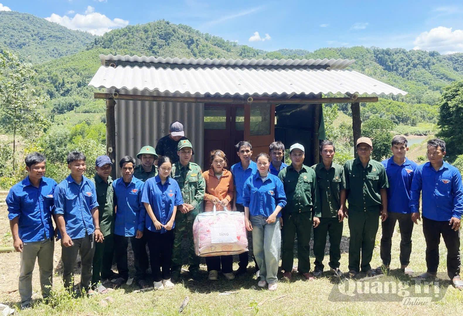 Cán bộ, chiến sĩ Đồn Biên phòng Ba Nang cùng Đoàn Thanh niên dựng lại nhà, trao chăn ấm cho chị Hồ Thị Pân - Ảnh: K.S