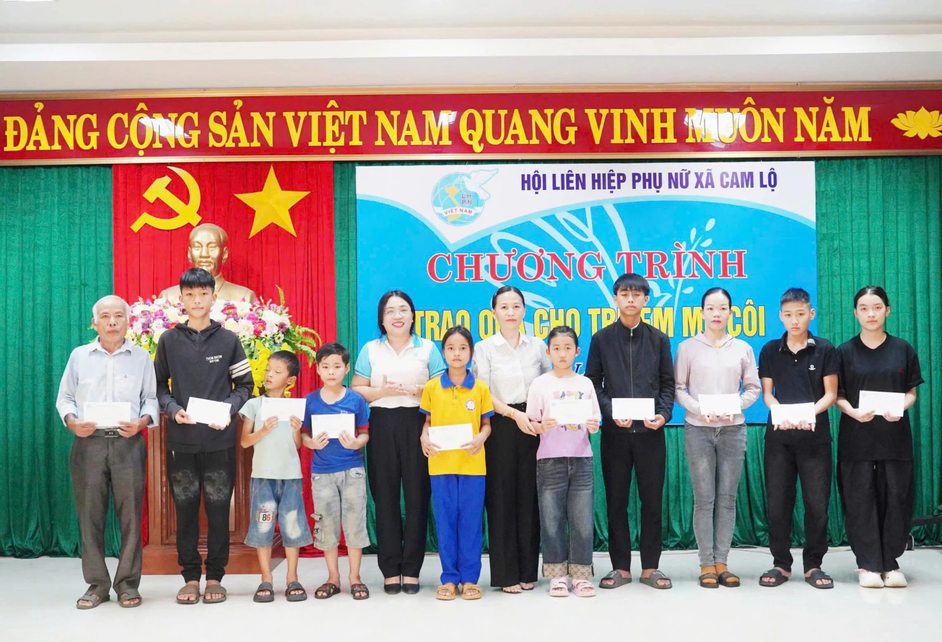 Chị Lê Thị Hường (thứ 5 từ trái sang) trao quà cho trẻ em mồ côi trên địa bàn xã Cam Lộ  - Ảnh: K.S