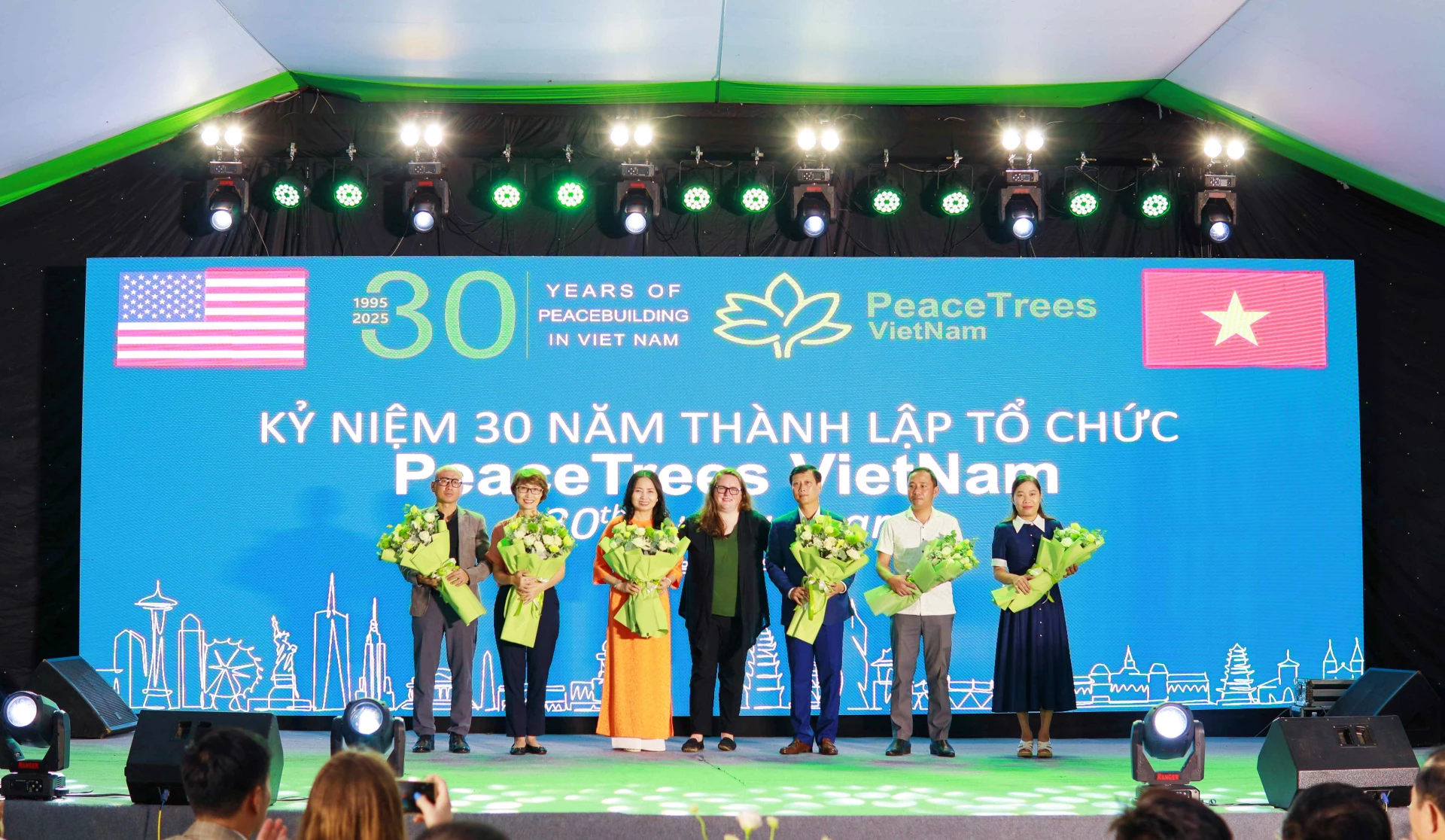 Bà Claire Yunker, Giám đốc điều hành PeaceTrees Vietnam (thứ 4, từ phải sang) tặng hoa cho các tổ chức, cá nhân có nhiều đóng góp vào sự phát triển của tổ chức-Ảnh: Q.H