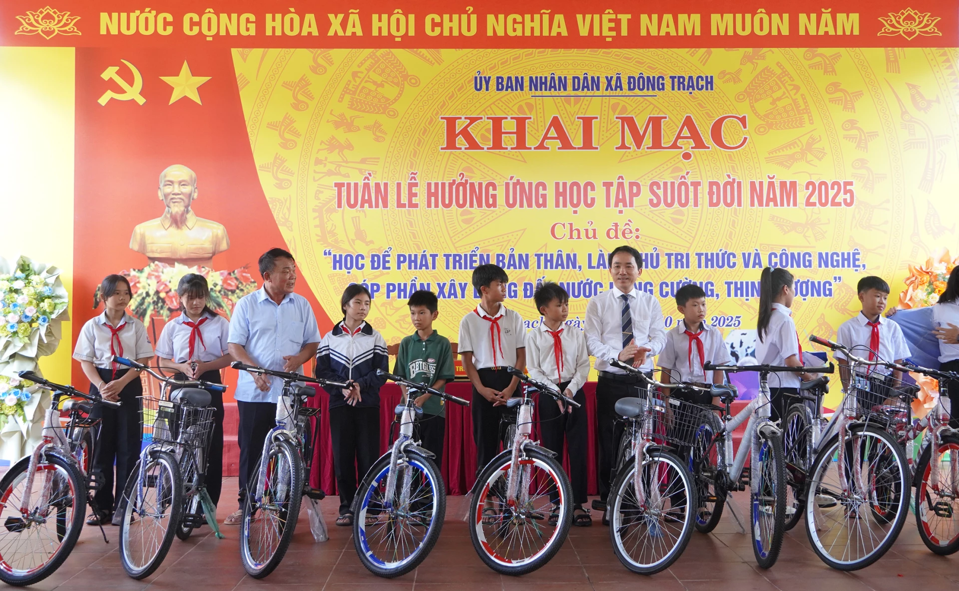 Đại diện lãnh đạo UBND xã Đông Trạch và doanh nghiệp tặng xe đạp cho các em học sinh - Ảnh: C.N

