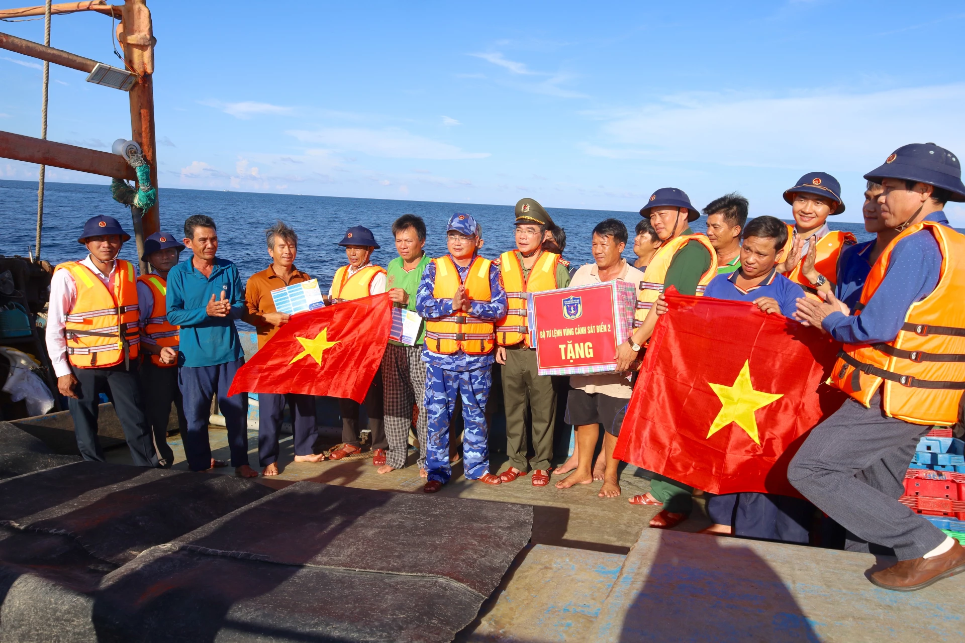 Đoàn công tác tặng cờ Tổ quốc cho bà con ngư dân trên biển - Ảnh: Q.N