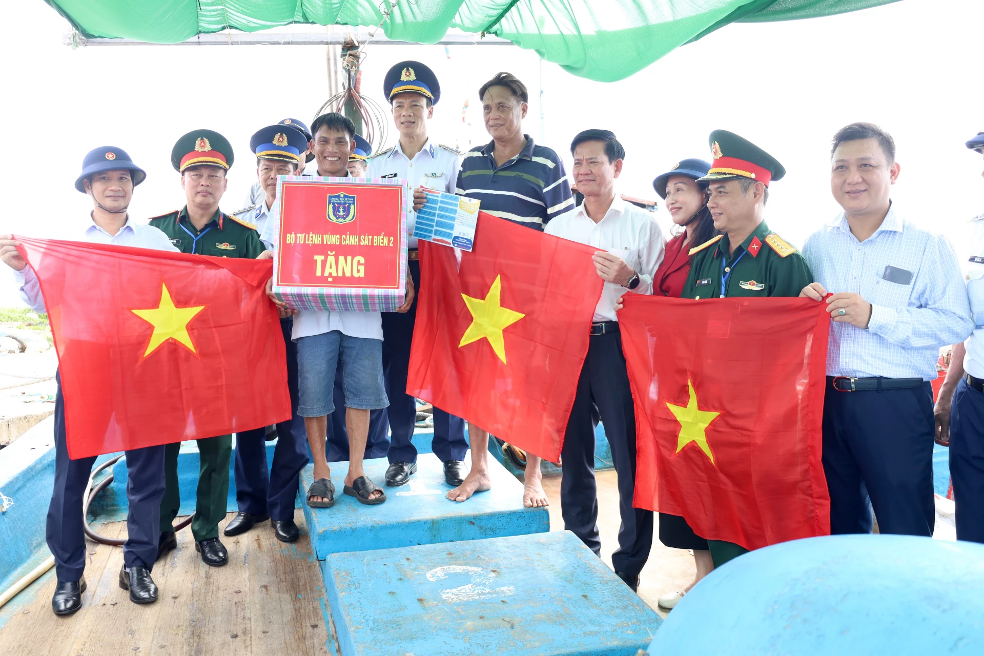 Đoàn công tác các địa phương đi khảo sát, nắm tình hình khu vực biển, đảo gần bờ năm 2025 tặng quà và tặng cờ Tổ quốc cho bà con ngư dân. Ảnh: Quang Ngọc.