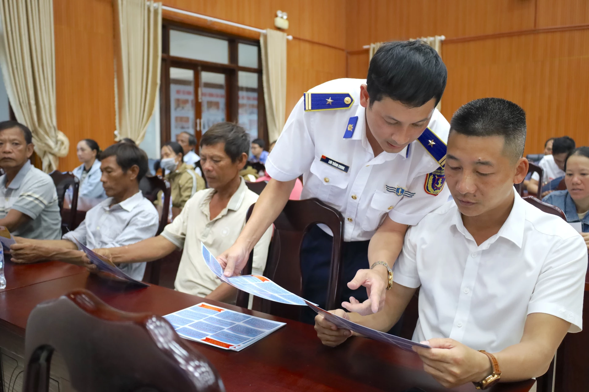 Cán bộ Vùng Cảnh sát biển 2 tuyên truyền các quy định chống khai thác hải sản bất hợp pháp, không báo cáo và không theo quy định (IUU) cho bà con ngư dân. Ảnh: Quang Ngọc