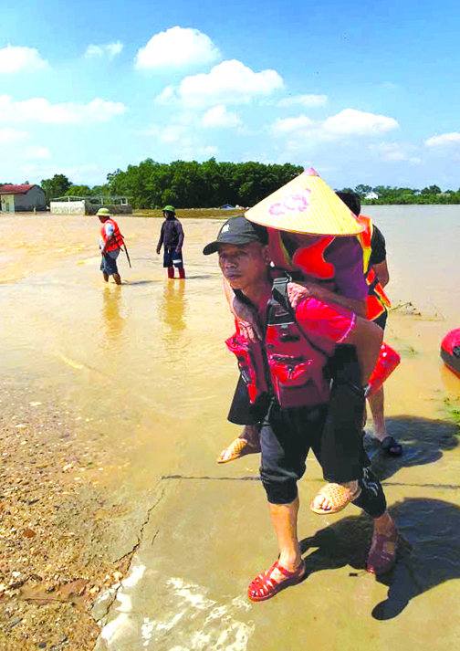 Anh Mậu Tuấn cõng một người già ở tỉnh Thái Nguyên từ vùng ngập sâu ra địa điểm an toàn- Ảnh:NVCC
