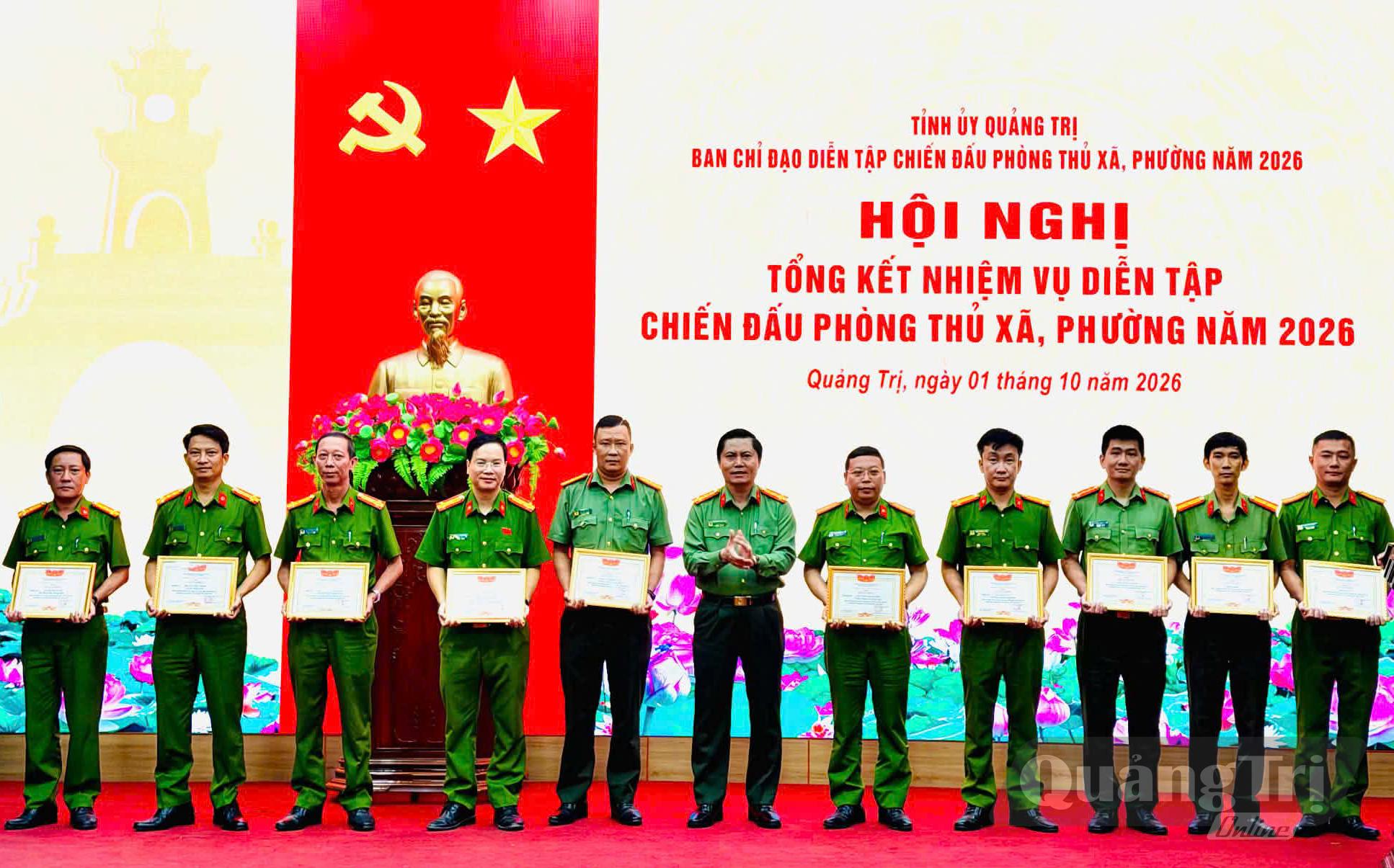 Thiếu tá Lê Thanh Xuân (ngoài cùng bên phải) nhận giấy khen tại hội nghị tổng kết nhiệm vụ diễn tập chiến đấu phòng thủ xã, phường năm 2026 - Ảnh: M.H