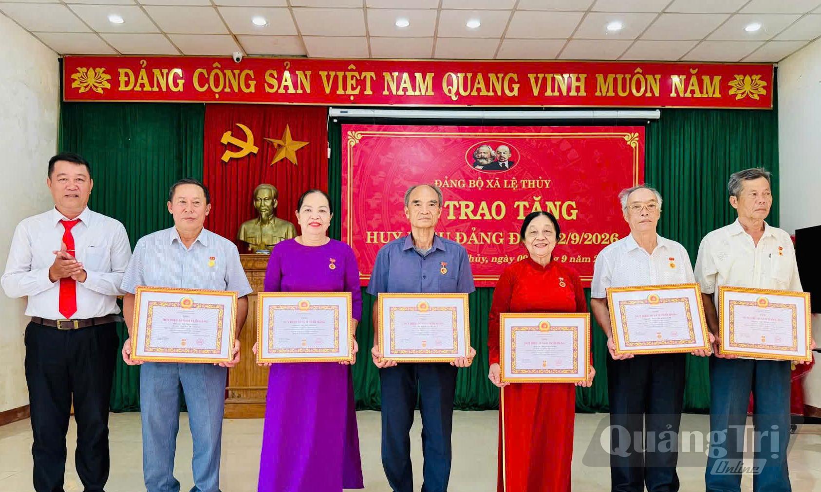Đại diện Ban Thường vụ Đảng ủy xã Lệ Thủy trao Huy hiệu Đảng cho đảng viên - Ảnh: P.V