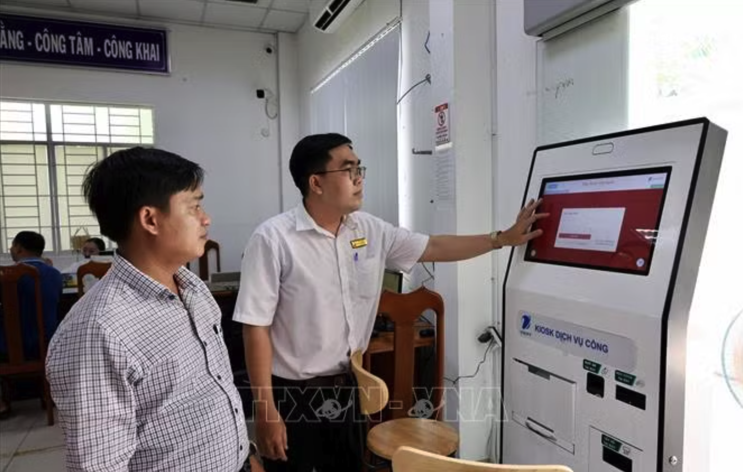 Cán bộ Trung tâm Phục vụ hành chính công phường Long Xuyên (An Giang) hướng dẫn người dân thực hiện thủ tục trực tuyến trên Cổng Dịch vụ công quốc gia. Ảnh minh họa: Thanh Sang/TTXVN