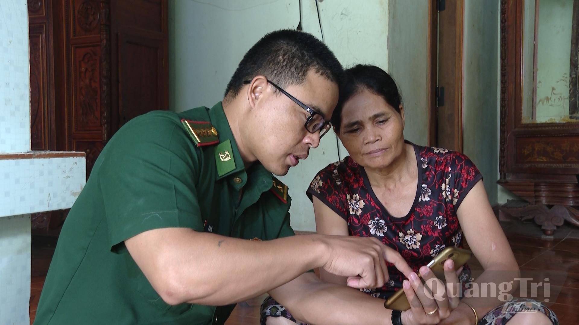 Bà Hồ Thị Thiện, xã Lìa được hướng dẫn thực hiện dịch vụ công trực tuyến trên điện thoại thông minh - Ảnh: M.L
