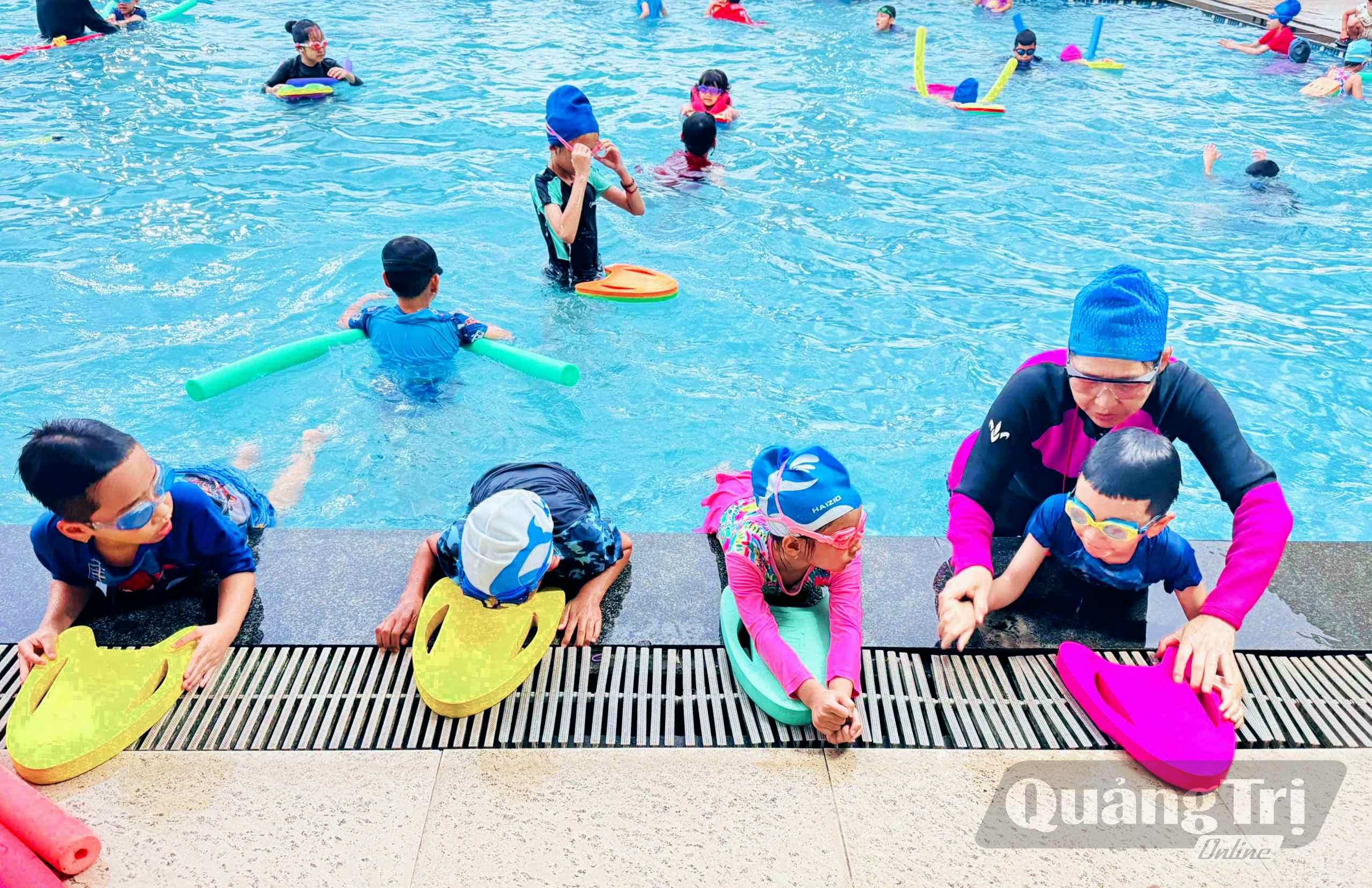 Cô Hạnh hướng dẫn kỹ năng bơi lội cho các em nhỏ - Ảnh: Q.H
