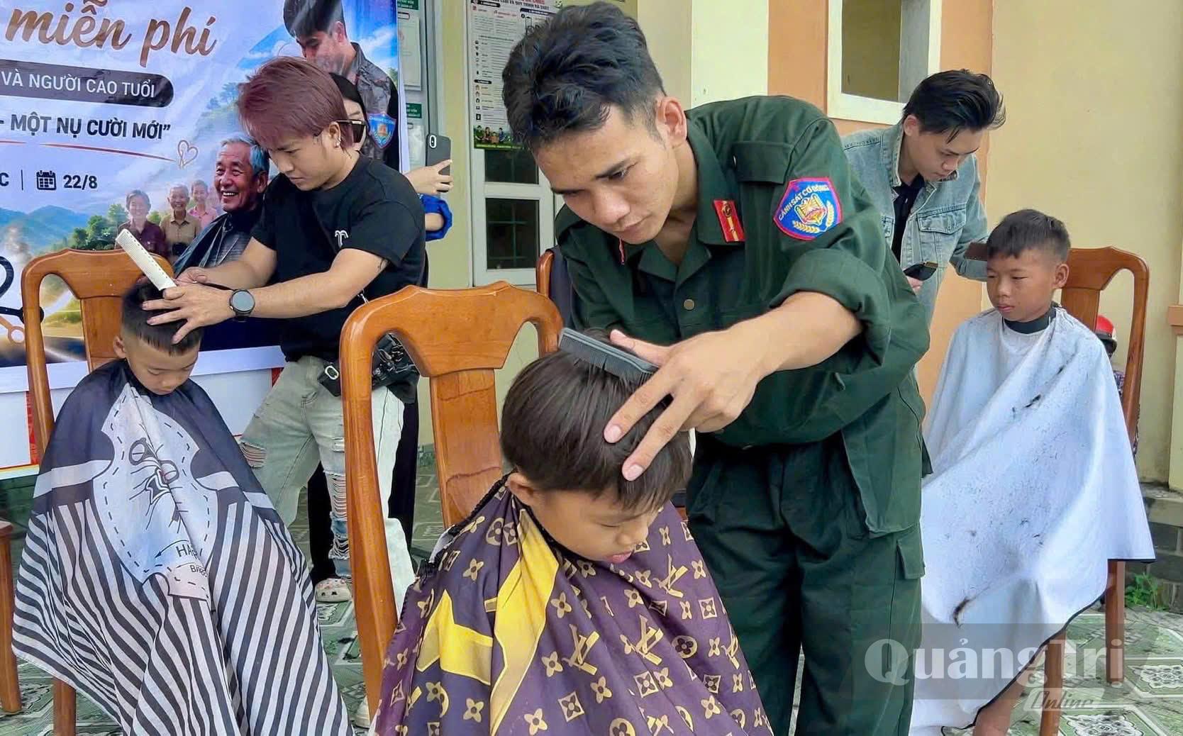 Các chiến sĩ Cảnh sát cơ động cắt tóc cho trẻ em trên địa bàn - Ảnh: P.P