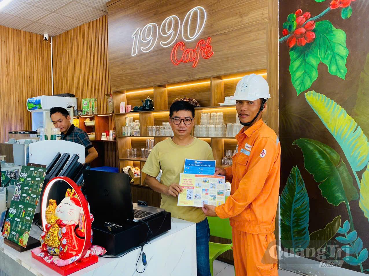 Cán bộ Điện lực Khe Sanh phát tờ rơi tuyên truyền sử dụng điện an toàn và phòng, chống cháy nổ cho các hộ kinh doanh - Ảnh: K.S