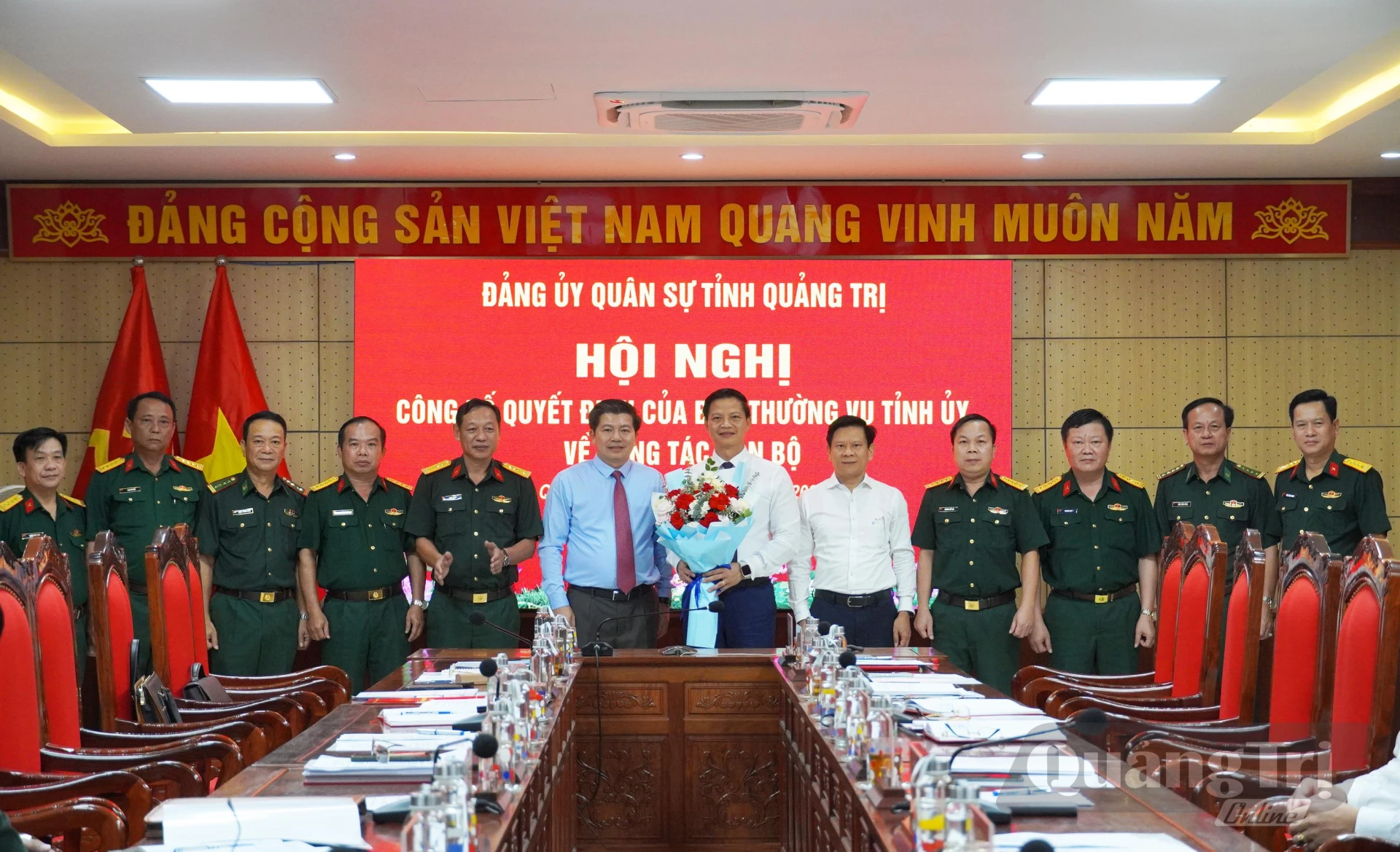 Các đại biểu tặng hoa, chụp hình lưu niệm với đồng chí Vương Quốc Tuấn, Bí thư Đảng ủy Quân sự tỉnh - Ảnh: X.P