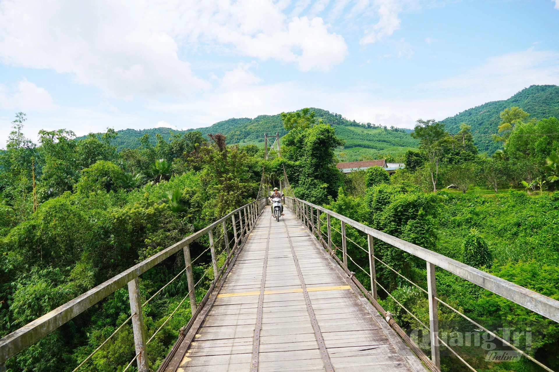 Mặc dù bị hư hỏng, xuống cấp nhưng hằng ngày vẫn có nhiều người qua lại cầu treo Kim Tiến - Ảnh: X.V