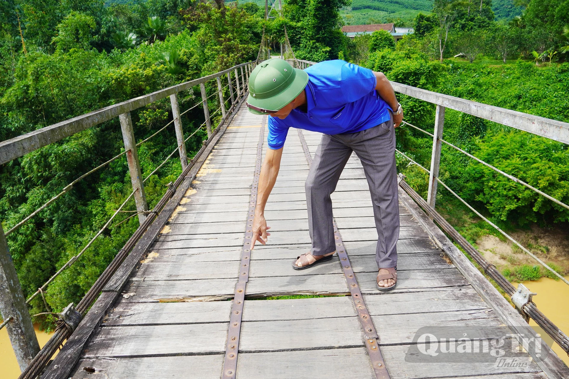 Cầu treo Kim Tiến vẫn còn nhiều tấm ván bị gãy, mục gây nguy hiểm cho người qua lại - Ảnh: X.V