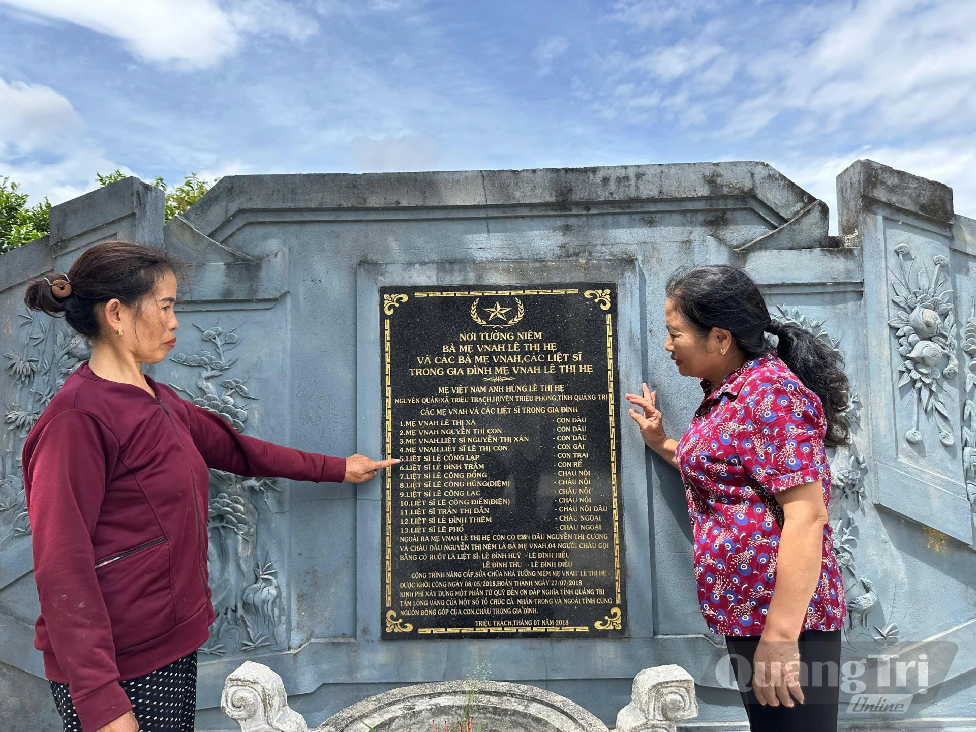 Bà Lê Thị Đẳng (góc phải ảnh) bên tấm bình phong nơi ghi danh đại gia đình kiên trung - Ảnh: Đ.V