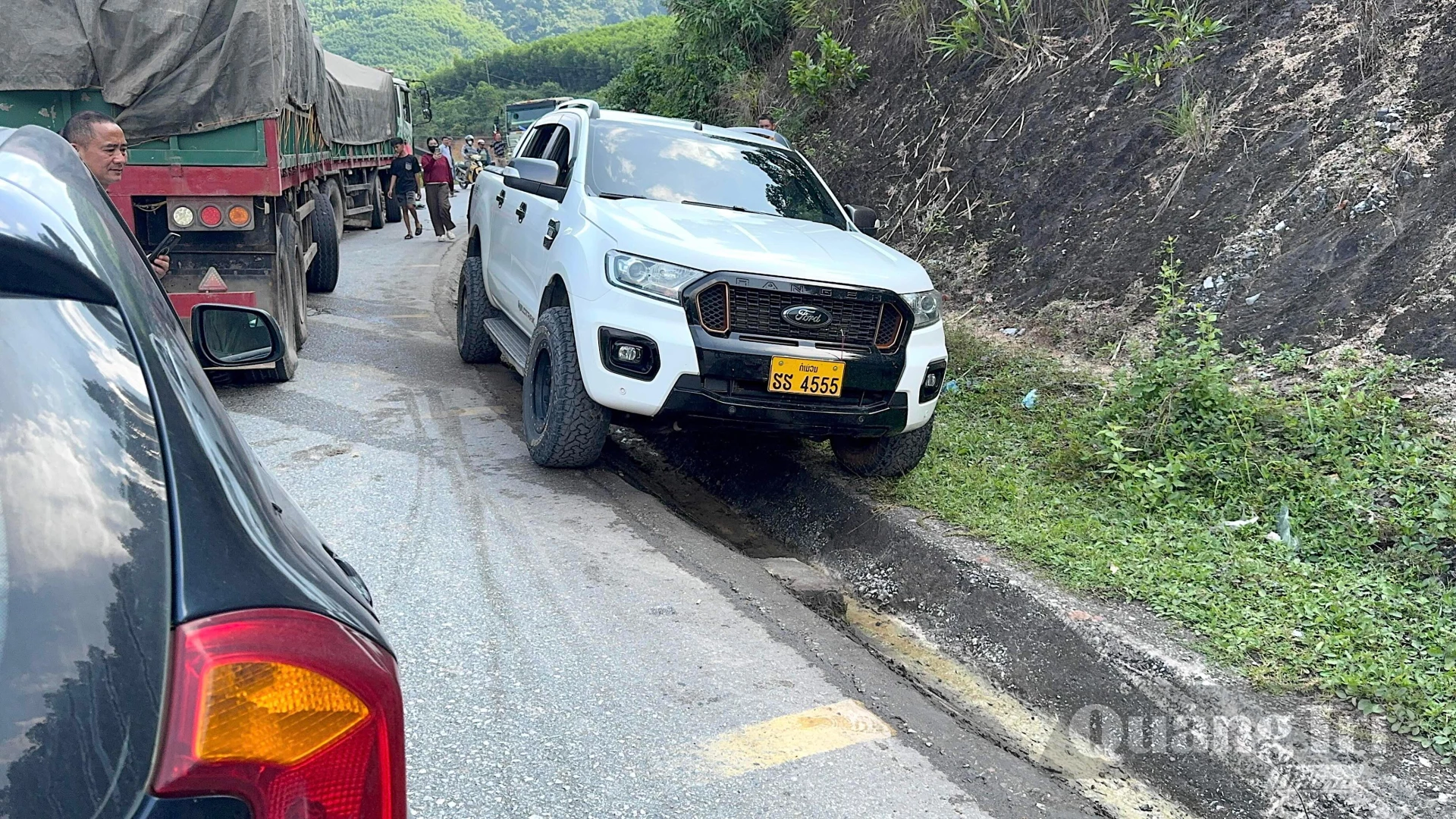 Một số phương tiện tìm cách vượt qua vị trí ùn tắc bằng rãnh thoát nước ven đường - Ảnh: Quang Ngọc.