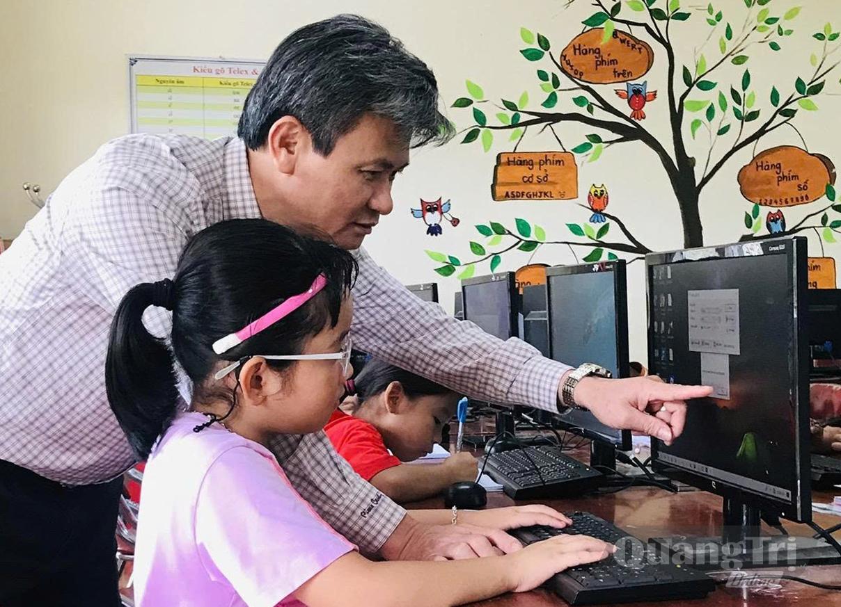 Thầy giáo Hoàng Tuấn Kiệt hướng dẫn học sinh thực hành máy tính - Ảnh: NVCC