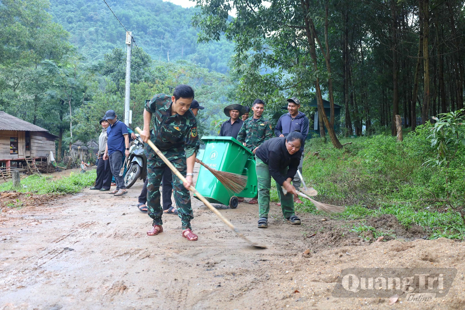 Cán bộ xã Dân Hóa cùng bà con bản Lòm - K. Chăm tham gia nạo vét cống rãnh, dọn đất bùn trên đường, góp phần giữ gìn vệ sinh môi trường, xây dựng bản làng sáng, xanh, sạch, đẹp - Ảnh: Q.N.